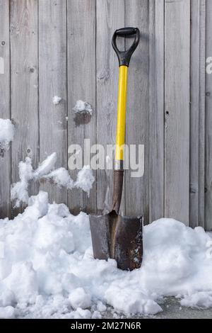 Pala da neve gialla in piedi nella neve. Pala invernale. Rimuovere la neve dopo la Blizzard. Nessuno, foto di strada Foto Stock