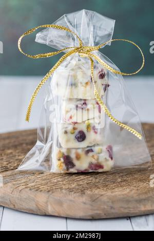 Fudge al cioccolato bianco al mirtillo rosso e pistacchio fatti in casa in una borsa regalo. Foto Stock
