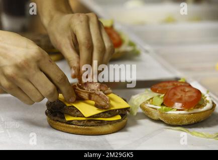 L'immagine mostra l'impiegato che prepara un hamburger durante l'apertura di una filiale della catena di ristoranti fast food Burger King ad Auderghem - Oudergem, Bruxelles, martedì 12 settembre 2017. FOTO DI BELGA NICOLAS MAETERLINCK Foto Stock