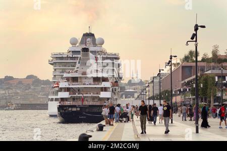 Istanbul, Turchia - 26 agosto 2022: Galataport , uno sviluppo a uso misto situato lungo la riva dello stretto del Bosforo, nel quartiere di Karakoy, con due grandi crociere ancorate, e pedoni che si svegliano Foto Stock