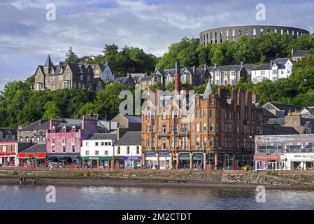 Negozi e McCaig's Tower su Battery Hill con vista sulla città Oban, Argyll e Bute, Scozia, UK | Vue sur McCaig's Tower à Battery Hill au ville d'Oban, Argyll e Bute, Ecosse, Royaume-uni 05/06/2017 Foto Stock