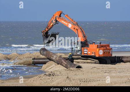 Escavatore idraulico installazione di condutture durante lavori di rifornimento di sabbia / nutrimento di spiaggia lungo la costa belga a Ostenda, Belgio | Construction de pipeline avec pelle mécanique hydraulique de Jan De Nul pour able de ricostituation sur la plage d'Ostende, Belgique 22/02/2018 Foto Stock