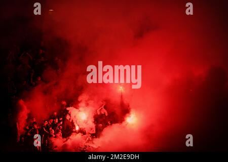 Il sostenitore di uno Standard tiene un fuoco d'artificio in fiamme nel fumo rosso, durante la partita della Jupiler Pro League tra KRC Genk e Standard de Liege, a Genk, sabato 07 aprile 2018, il secondo giorno del Play-off 1 del campionato di calcio belga. FOTO DI BELGA YORICK JANSENS Foto Stock