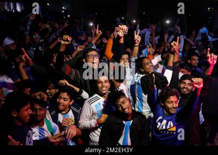 Dhaka, Bangladesh. 14th Dec, 2022. I fan del Bangladesh festeggiano la vittoria dell'Argentina nella semifinale della Coppa del mondo FIFA mentre guardano la partita su uno schermo gigante presso la Jagannath Hall dell'Università di Dhaka, in Bangladesh, il 14th dicembre 2022. (Credit Image: © Md Rakibul Hasan/ZUMA Press Wire) Foto Stock