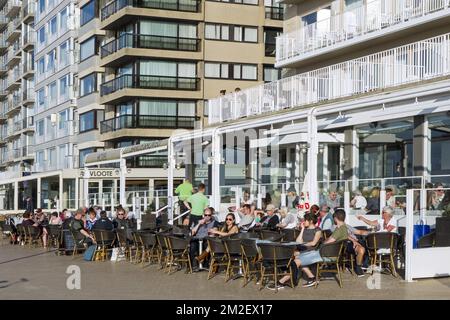 Turisti seduti in una caffetteria sul marciapiede nella località balneare Nieuwpoort / Nieuport lungo la costa belga del Mare del Nord, Belgio | Touristes sur terrasse à Nieuport, Belgique 18/04/2018 Foto Stock