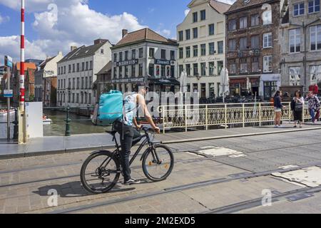 Il corriere di bicicletta consegna i pasti nel centro della città di Gand, Belgio per Deliveroo, azienda britannica di consegna di alimento in linea | Coursier à vélo de Deliveroo, servizio de livraison de plats cuisinés à Gand, Belgique 03/05/2018 Foto Stock