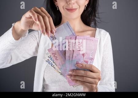 Una donna tira fuori una banconota di valuta in Hryvnia Ucraina UAH nominale 50. Donna tenere ventilatore di hryvnya. Il concetto di finanza della Repubblica Ceca. CZK piccola nominale bankN Foto Stock