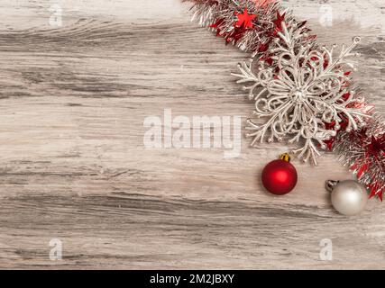 Natale sfondo in legno con decorazioni e tinsel rosso e argento Natale Foto Stock