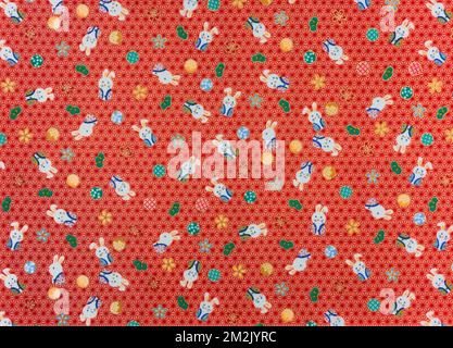 Fotografia di un tradizionale tessuto furoshiki giapponese stampato con conigli carini in hakama simbolo di fortuna, muovendosi in avanti e bravura contro a. Foto Stock