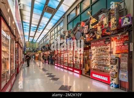 tokyo, giappone - 06 2022 agosto: Vetrine dello spettacolo sormontate da copertine di yokai folcloristico giapponese e manga retrò nel corridoio del Nakano Broadway Shopping Foto Stock