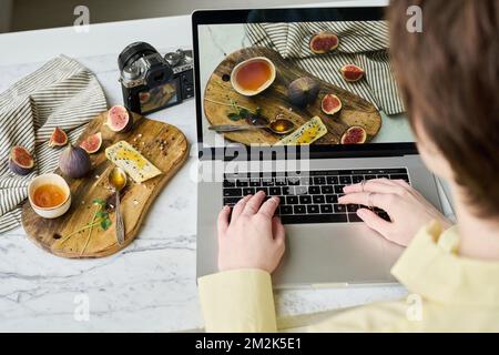 Primo piano di un giovane grafico che ritocchi foto professionali di una vita morta sul notebook Foto Stock