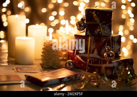 regali fotografici e candele accese sul tavolo Foto Stock