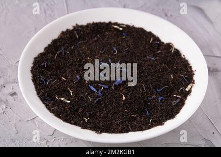 Foto di tè nero sfuso Earl Grey in un piatto bianco Foto Stock
