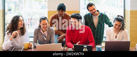 Banner orizzontale o intestazione multirazziale gruppo di giovani che lavorano intorno a computer con volti positivi e sorridenti. Foto Stock