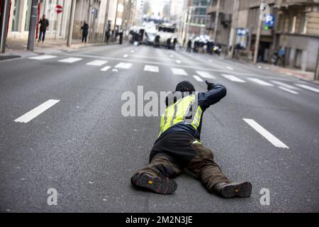 L'illustrazione mostra un protestore che si è posato sulla strada e un sacco di forze di polizia sul retro della strada per una protesta dei giubbotti gialli (Gilets jaunes - gele hesjes) contro l'aumento dei prezzi del carburante e del petrolio, nel centro di Bruxelles, sabato 15 dicembre 2018. BELGA FOTO HATIM KAGHAT Foto Stock