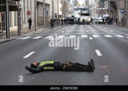 L'illustrazione mostra un protestore che si è posato sulla strada e un sacco di forze di polizia sul retro della strada per una protesta dei giubbotti gialli (Gilets jaunes - gele hesjes) contro l'aumento dei prezzi del carburante e del petrolio, nel centro di Bruxelles, sabato 15 dicembre 2018. BELGA FOTO HATIM KAGHAT Foto Stock