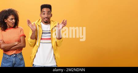 Jeez uomo che il vostro problema. Offeso dispiaciuto afroamericano elegante e attraente ragazza che guarda il ragazzo comportandosi cool fingendo lui Foto Stock