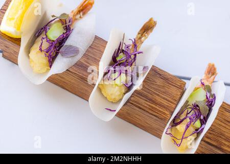 Cibo gourmet primo piano di brochette di gamberi alla griglia condite con erbe naturali su piatto di legno. Cocktail di gamberi con lattuga e avocado, lusso Foto Stock