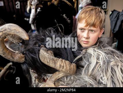 Un ragazzo dai capelli rossi con un reckle in costume di Krampus sta in attesa della processione, Austria, Salisburgo Foto Stock