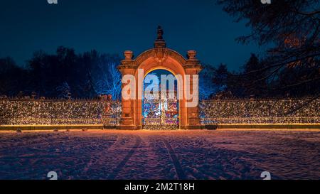 Cancello d'ingresso principale illuminato del Giardino Zoologico Silesiano situato nel Parco Silesiano, Chorzow, Polonia. Bellissimo scenario invernale. Illuminazione colorata Foto Stock