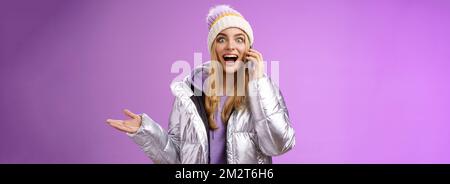 Talkative Amused bionda ragazza sentire impressionante buona notizia alzare mano sorpreso felice parlare smartphone allargare gli occhi soddisfatto perfetto informazioni, in piedi Foto Stock