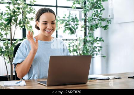 Conversazione online. Positivo successo latino o brasiliana donna, si siede a una scrivania, parlando in videoconferenza con un collega o cliente, assumere manager conduce un colloquio con il candidato Foto Stock