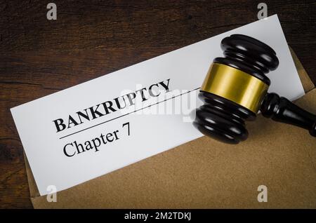 Bankcrupty Capitolo 7 testo su modulo di documento e Gavel di legno sulla scrivania dell'ufficio. Foto Stock