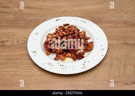 Una tipica tapa di barrette spagnole con orecchie grigliate con salsa da immersione su un piatto rotondo con prezzemolo ai bordi Foto Stock