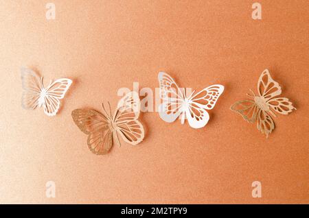 La carta farfalle su uno sfondo di carta arancione con spazio vuoto. Foto Stock