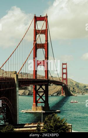 Bellissima immagine del Golden Gate Bridge a San Francisco. Apprezza la scala di questo famoso ponte rispetto a una piccola barca da pesca sottostante. Foto Stock