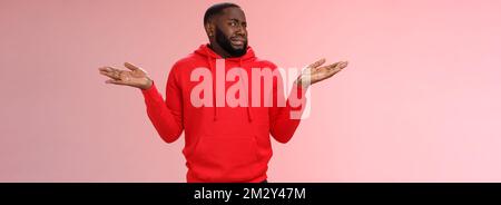 L'uomo afro-americano fringe shake head ignaro accigliato grimacing avversione dissimile shrugging mani alzate lateralmente non hanno idea, in piedi insoddisfatto Foto Stock