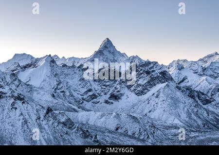 Bella Ama Dablam picco illuminato dai primi raggi del sole del mattino. La cima di montagna si erge tra la catena montuosa dell'Himalaya. Stupenda vista panoramica Foto Stock