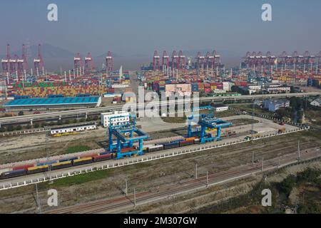Ningbo. 13th Dec, 2022. This aerial photo taken on Dec. 13, 2022 shows gantry crane loading and uploading containers of sea-rail intermodal trains at Ningbo-Zhoushan Port in east China's Zhejiang Province. The cargo and container throughput of Ningbo-Zhoushan Port registered year-on-year growth of 3.41 percent and 7.84 percent respectively in the first 11 months in 2022. The port saw its cargo throughput reach 1.16 billion tons while the container throughput achieved 31.26 million twenty-foot equivalent units (TEUs). Credit: Huang Zongzhi/Xinhua/Alamy Live News Stock Photo