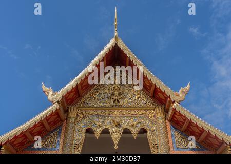 Vista di Viharn Luang o del principale timpano vihara con sculture in legno dorato presso l'antico simbolo Lanna, il tempio buddista Wat Phra Singh, Chiang mai, Thailandia Foto Stock