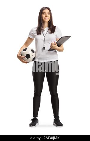 Ritratto completo di una allenatrice di calcio femminile con un fischio che tiene un clipboard e una palla isolata su sfondo bianco Foto Stock