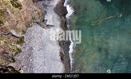 Bellissima spiaggia rocciosa sulla costa meridionale dell'Irlanda vicino a Clonakilty. La pittoresca costa del Mar Celtico. Surf in mare. Acque turchesi dell'Atlante Foto Stock