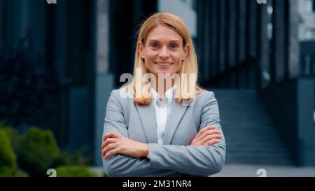 Donna caucasica che cammina all'aperto riuscito fidato imprenditore professionista manager leader imprenditore dipendente aziendale posa con le armi Foto Stock