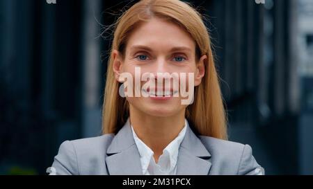 Zooming in su fuoco primo piano-su ritratto femminile di affari caucasian bella donna modello sorridente in posa all'aperto sicuro donna d'affari di successo Foto Stock