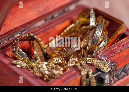 Gioielli d'oro e monete d'oro nel cesto di legno Foto Stock