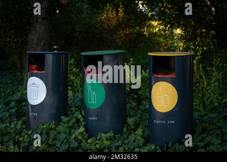 Riciclare i rifiuti in base alle categorie o riciclare i bidoni vicino a un campeggio in una foresta, riciclare plastica, lattina e vetro, smistare i rifiuti Foto Stock