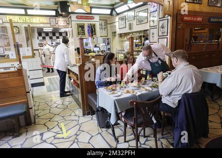 L'immagine mostra un cameriere e i clienti al famoso ristorante Leon, con stampi e patatine di specialità belghe, lunedì 08 giugno 2020. Oggi è il primo giorno della fase 3 del definement. Il settore dell'oreca può riaprirsi, ma deve applicare regole di allontanamento sociale nelle proprie imprese. FOTO DI BELGA THIERRY ROGE Foto Stock