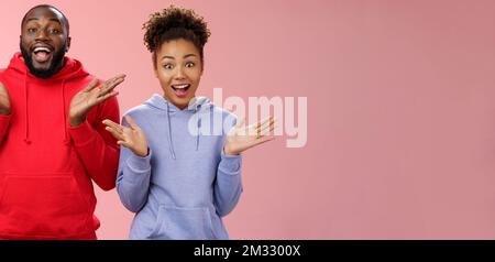Impressionato felice emozionato giovane coppia africano uomo donna relazione clapping palme felicemente sorpreso occhi larghi gioiosamente saluto amici che invitano venire Foto Stock