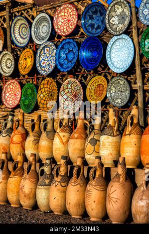 Tazentout, Ouarzazate, Marocco - 28 novembre 2022 - Una serie di piatti tradizionali marocchini in argilla fatti a mano nel negozio locale. Ciotole, piatti, tagine, ju Foto Stock