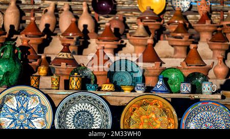 Tazentout, Ouarzazate, Marocco - 28 novembre 2022 - Una serie di piatti tradizionali marocchini in argilla fatti a mano nel negozio locale. Ciotole, piatti, tagine, ju Foto Stock