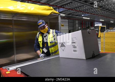 L'immagine mostra i lavoratori in azione presso l'hub DHL dell'aeroporto di Bruxelles, martedì 01 dicembre 2020 a Zaventem. L'aeroporto di Bruxelles e il partner della comunità Air Cargo Belgium hanno istituito la task force BRUcure per la logistica relativa al trasporto del vaccino Covid-19. FOTO DI BELGA DIRK WAEM Foto Stock