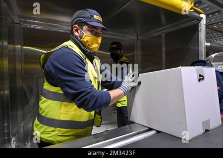 L'immagine mostra i lavoratori in azione presso l'hub DHL dell'aeroporto di Bruxelles, martedì 01 dicembre 2020 a Zaventem. L'aeroporto di Bruxelles e il partner della comunità Air Cargo Belgium hanno istituito la task force BRUcure per la logistica relativa al trasporto del vaccino Covid-19. FOTO DI BELGA DIRK WAEM Foto Stock