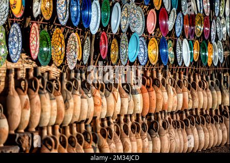 Tazentout, Ouarzazate, Marocco - 28 novembre 2022 - Una serie di piatti tradizionali marocchini in argilla fatti a mano nel negozio locale. Ciotole, piatti, tagine, ju Foto Stock