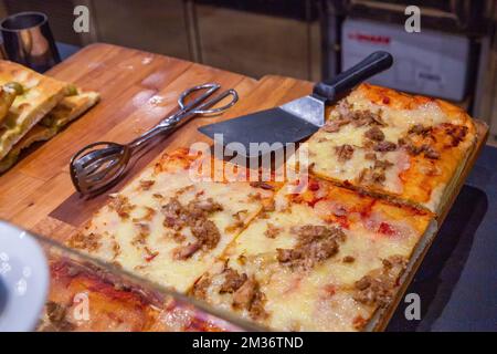 Pizza italiana in Italia! P{izzaa con pane, formaggio e carne (prosciutto o prosciutto di Parma, Prosciutto di Parma) in vendita al banco Foto Stock