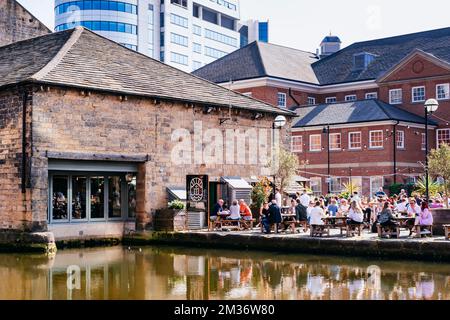 Persone che si trovano in terrazza. Waterman's Place. Granary Wharf è uno sviluppo a uso misto che si trova accanto ai tunnel in mattoni accanto a Leeds e Liverp Foto Stock