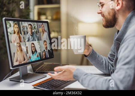 Maschio che ha videochat con i colleghi Foto Stock